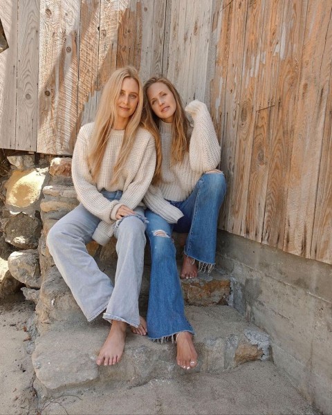 Zwei Frauen sitzen auf einer Treppe und tragen ética Jeans