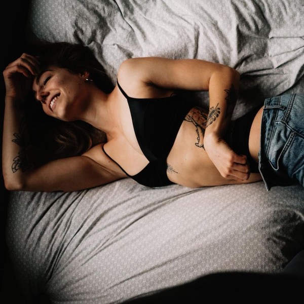 Frau liegt im Bett und traegt nachhaltige Unterwaesche von AIKYOU
